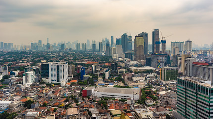 Obraz premium Jakarta, Indonesia - 19th Feb 2019: Aerial or bird eye view of Jakarta Central Business District (Sudirman and Kuningan). Rich and poor inequality. Taken at a cloudy afternoon.