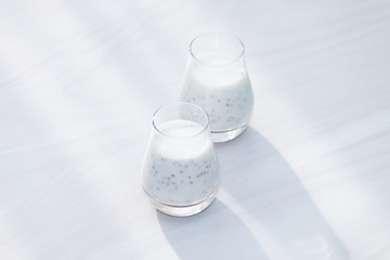 Healthy vanilla chia pudding on white wooden background. Morning, sunlight. Copy space.