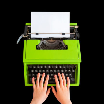 Hands typing on retro typewriter