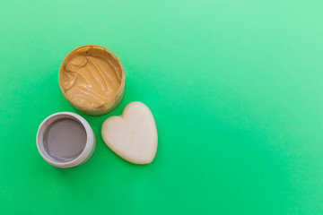 Cosmetic cream, scrub and heart-shaped soap top view