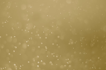 Yellow glitter vintage lights background. White bokeh on yellow background.