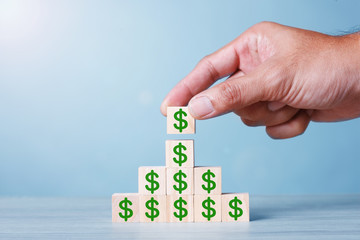 Wood block cubic stacking up with Green Dollar Sign. Blue Tone. Business growth success process. Business Concept Up Trend.