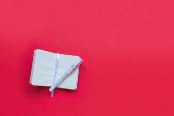 Fashionable marble notepad and pen on pink background