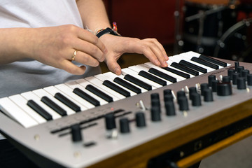 Obraz premium Electronic synthesizer and part of a woman's hand in close-up.