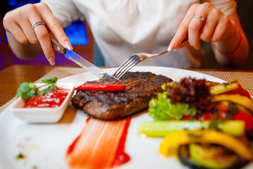 Medium-sized steak with vegetables in a cafe.