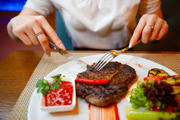 Medium-sized steak with vegetables in a cafe.