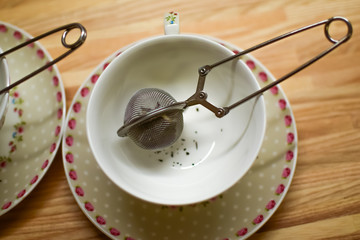 Empty tea cups with tea strainer.