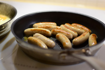 Fried sausages at the time of cooking in a pan. 