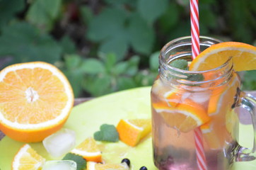Infused detox water with orange, blueberry and mint. Ice cold summer cocktail or lemonade in glass mason jar diet, body cleansing, healthy lifestyle.