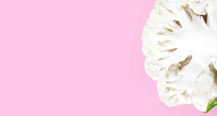 Close-up of cauliflower halves on pink pastel background. Freshness concept, vegan, vegetable background, banner, food blog. Top view, details of the texture of cabbage with copy space.