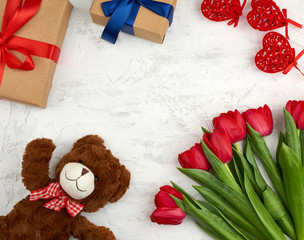 cute brown teddy bear, bouquet of red tulips, gift box, festive backdrop for birthday
