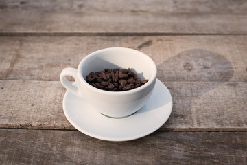 Cup of coffee beans on a wooden table