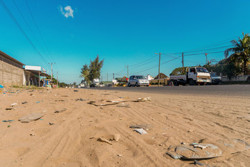 Fototapeta premium Ruchliwa droga z wieloma śmieciami wzdłuż niej w Maputo w Mozambiku