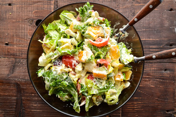 Vegetable spring-summer salad in a plate. Top view. Healthy food, bell pepper, avocado, dressing, tomatoes. Vegetarianism and veganism. Healthy lunch. Horizontal view.