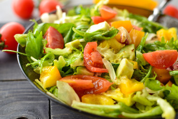 Healthy vegan food. Useful vegetable salad dressing, tomatoes, bell peppers, avocado. Close-up. Vegetarianism and veganism.