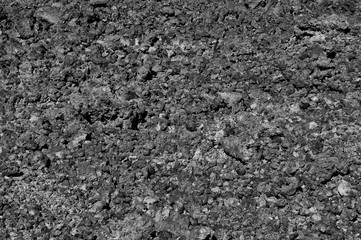 Rough volcanic soil at the foot of the Teide volcano. Nature texture of the lava surface. Black and white abstract minimalism.