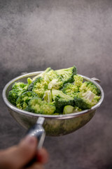 Green fresh brocolli in a colander.