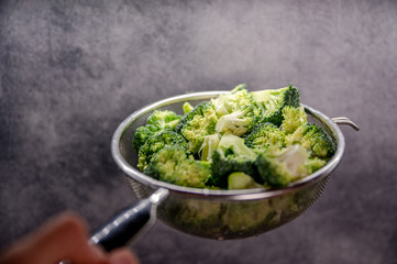 Green fresh brocolli in a colander.