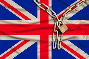 iron chain and castle on the Great Britain silk national flag with beautiful folds, the concept of a ban on tourism, political repression, crime, violation of the rights and freedoms of citizens