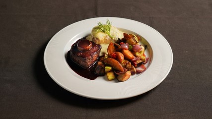Beef steak with soy sauce, baked potatoes and vegetables.  