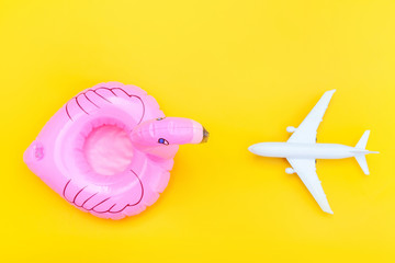 Summer beach composition. Minimal simple flat lay with plane and Inflatable flamingo isolated on...