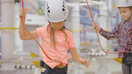 Little boy and girl playing in indoor climbing adventure park.