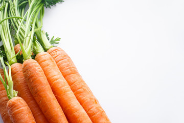 Close-up composition with ripe fresh carrots on white background, flat lay with space for text.