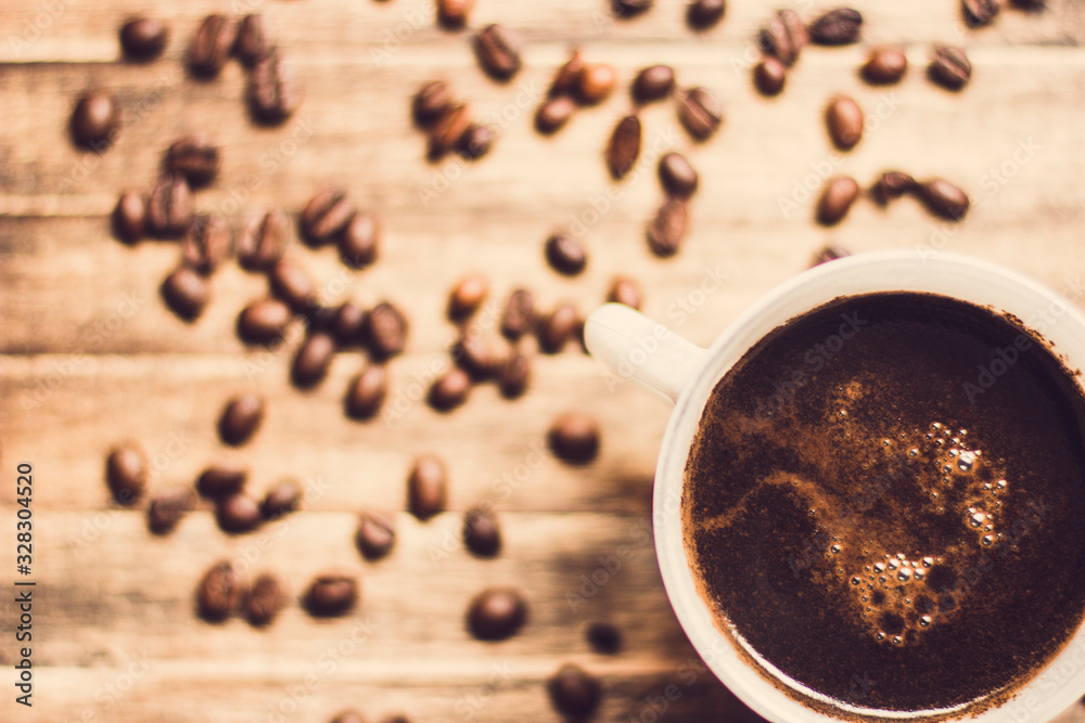 Wall mural cup of coffee and beans on wooden background