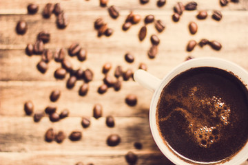 cup of coffee and beans on wooden background