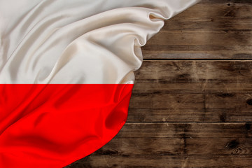 colored silk national flag of poland state lies on old wood, concept of tourism, economy, politics