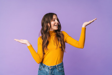 Image of young beautiful woman smiling and holding copyspace at her palms