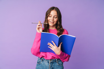 Image of young beautiful student girl smiling and holding exercise book