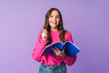 Image of young beautiful student girl smiling and holding exercise book
