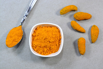 Closeup view of turmeric and turmeric powder in a bowl