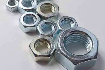 New chrome screw-nut of different sizes on a white background. Concept.