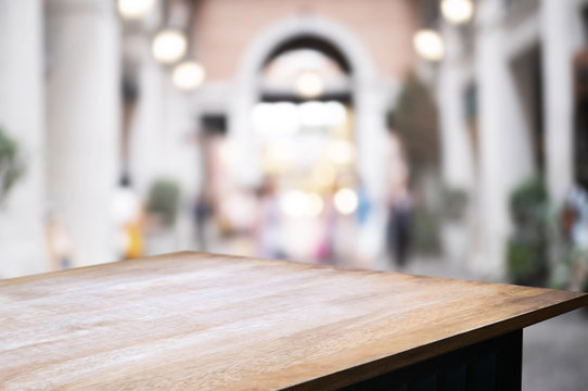 empty wood table over blurred montage outdoor cafe background