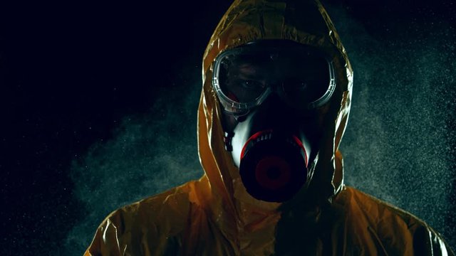 Super Slow Motion Shot of Man in Hazmat Suit and Blowing Aerosol at 1000 fps.