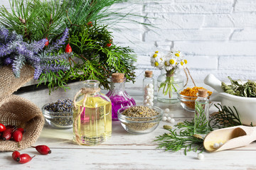 Variety of herbs and herbal mixtures as an alternative medicine concept on wooden table background over brick wall.