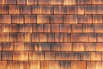 Facade covered with wooden weathered shingles.
