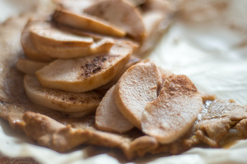 Apple slices in focus. Apple pie in blur. Food background 