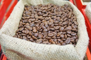 Coffee beans roasted to golden and brown are on the counter in the store
