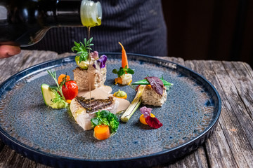 grilled sea bass fillet with cooked vegetables and potato pie