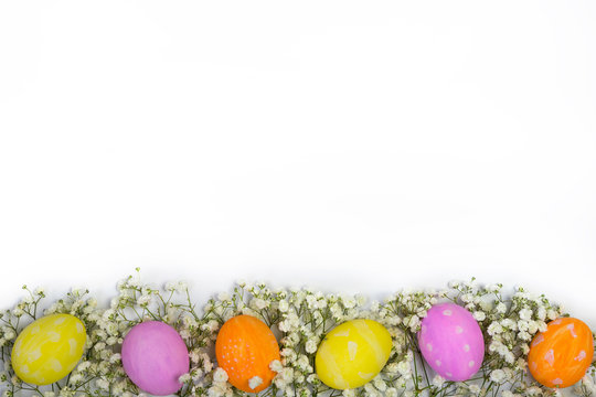Easter composition with colored eggs and flowers. Top view with free space for text.