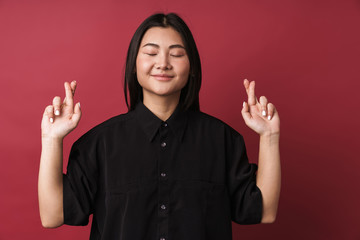 Optimistic young woman make fingers crossed