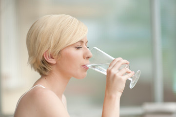 Beautiful young woman with glass of water