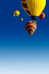 Traveling around the world - multicolored balloons on a blue sky with copy space for your text. Romantic weekend in the seventh sky or a tourist poster about your dreams of journey in vivid colors.
