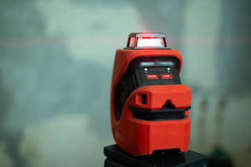 Laser level, used in apartment renovation. Optical instrument for accurate horizon level.