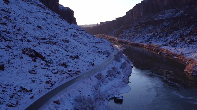 Aerial Drone Footage of Colorado River in Winter Near Moab, Utah U.S.A. Following Cars Approaching Flyover Below
