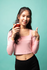 Young Asian woman thumbs up with tomato juice.