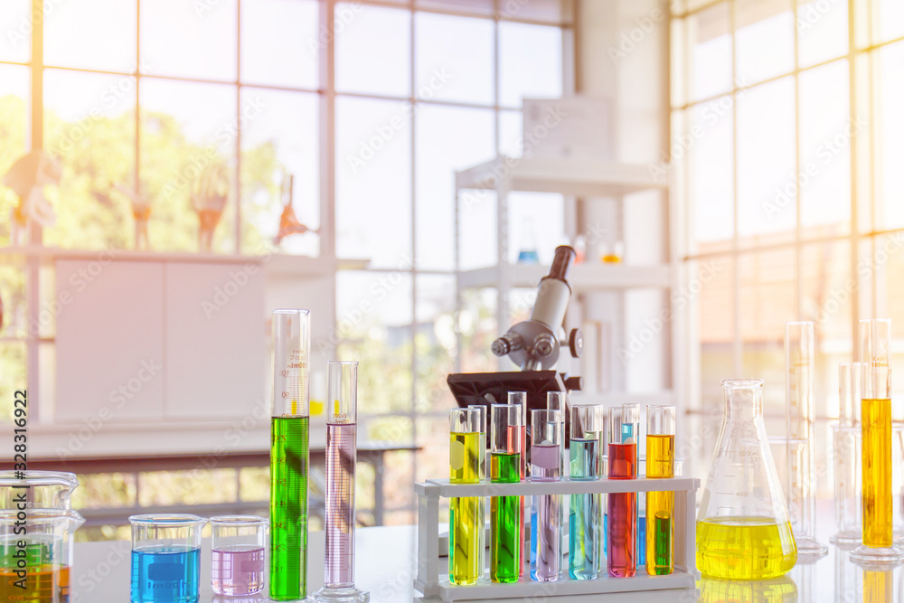 Poster chemical reagent in scientific experiment flasks of various shapes, sizes and with orange light.